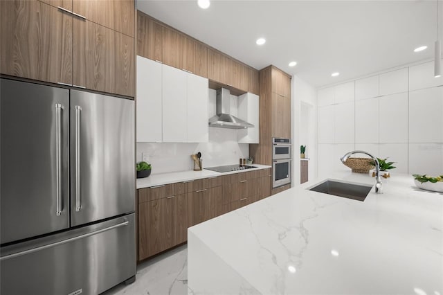 4726 Rivetta Ct, Sarasota, FL 34231 - kitchen featuring appliances with stainless steel finishes, a sink, wall chimney range hood, modern cabinets, and light stone countertops