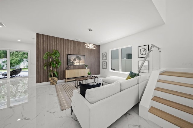 4726 Rivetta Ct, Sarasota, FL 34231 - living room featuring light marble finish flooring, an accent wall, stairs, recessed lighting, and wood walls