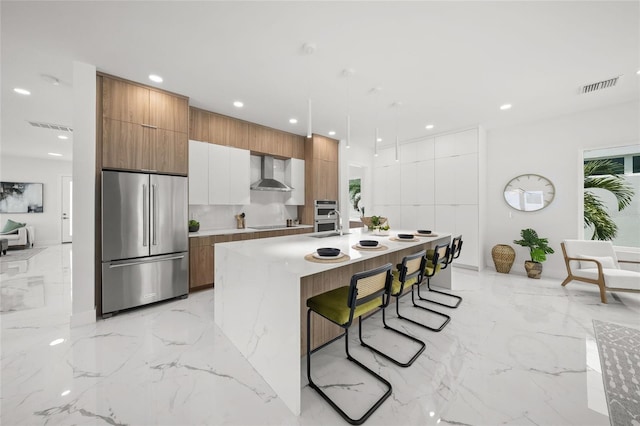 4726 Rivetta Ct, Sarasota, FL 34231 - kitchen with stainless steel appliances, modern cabinets, wall chimney exhaust hood, light marble finish flooring, and recessed lighting