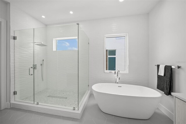 4726 Rivetta Ct, Sarasota, FL 34231 - full bath featuring tile patterned floors, a freestanding tub, a stall shower, recessed lighting, and baseboards