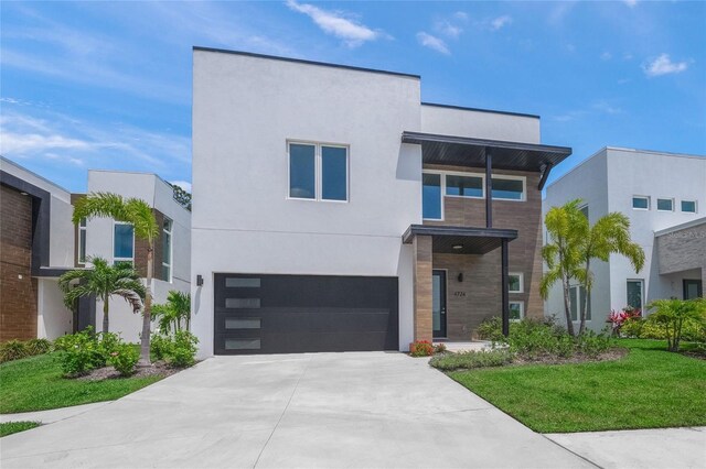4726 Rivetta Ct, Sarasota, FL 34231 - modern home with an attached garage, concrete driveway, stucco siding, and a front lawn
