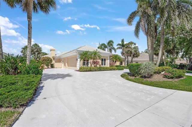 8 Dominica Dr, Englewood, FL 34223 - view of front of home featuring curved driveway, an attached garage, and a chimney
