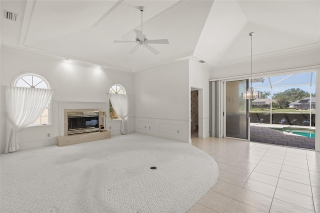 8 Dominica Dr, Englewood, FL 34223 - unfurnished living room featuring plenty of natural light, high vaulted ceiling, wainscoting, a glass covered fireplace, and a chandelier