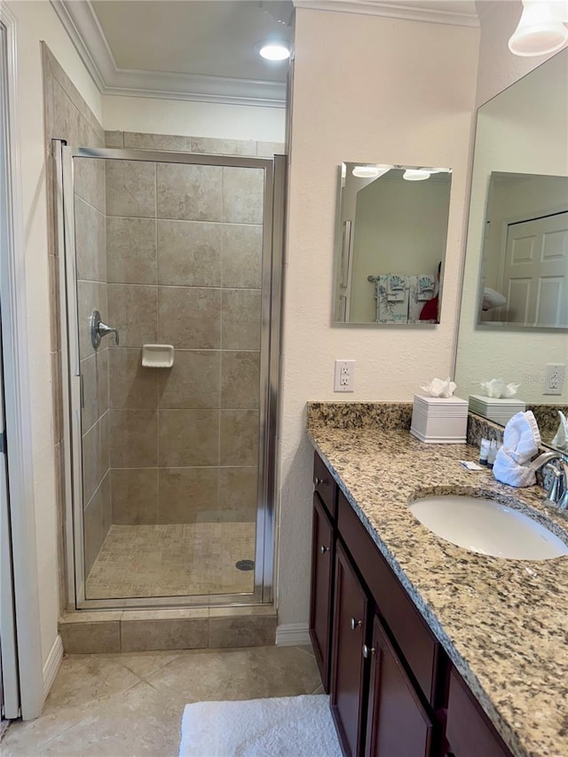 full bath featuring crown molding, a stall shower, vanity, and baseboards