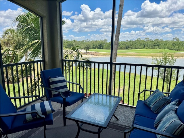 balcony featuring a water view and view of wooded area