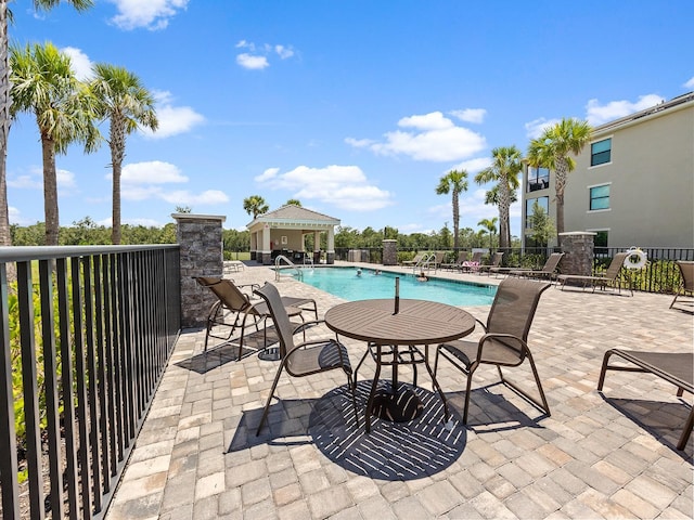 community pool with fence and a patio