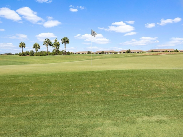 view of home's community featuring golf course view and a lawn