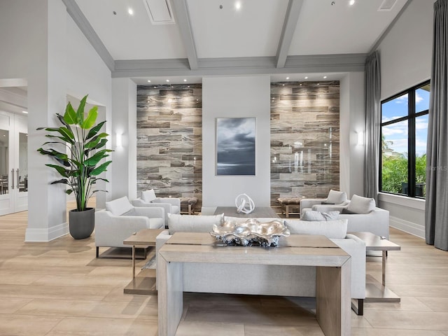 living room featuring beam ceiling, light wood-type flooring, and baseboards