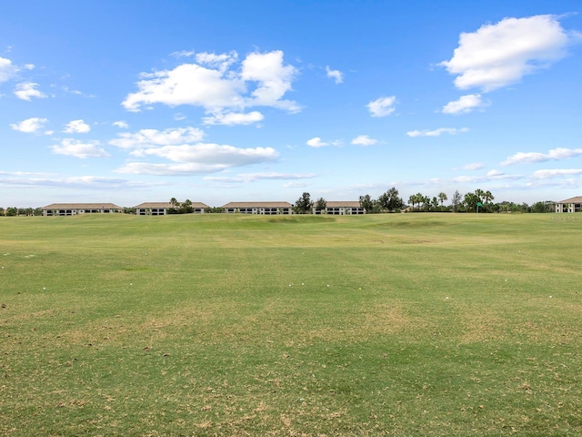 view of green lawn featuring golf course view