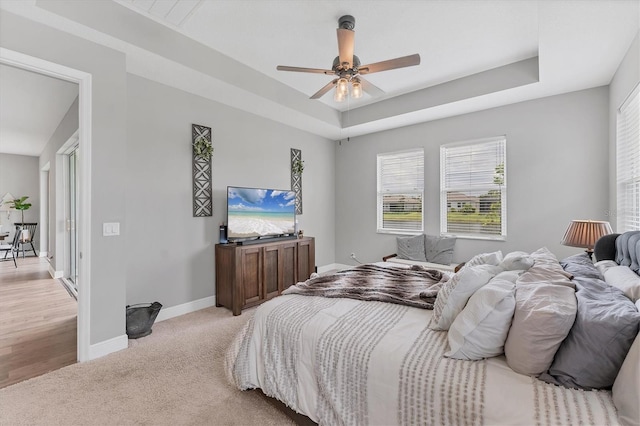 1017 Fernleaf Run, Bradenton, FL 34212 - bedroom with baseboards, light colored carpet, a raised ceiling, and ceiling fan