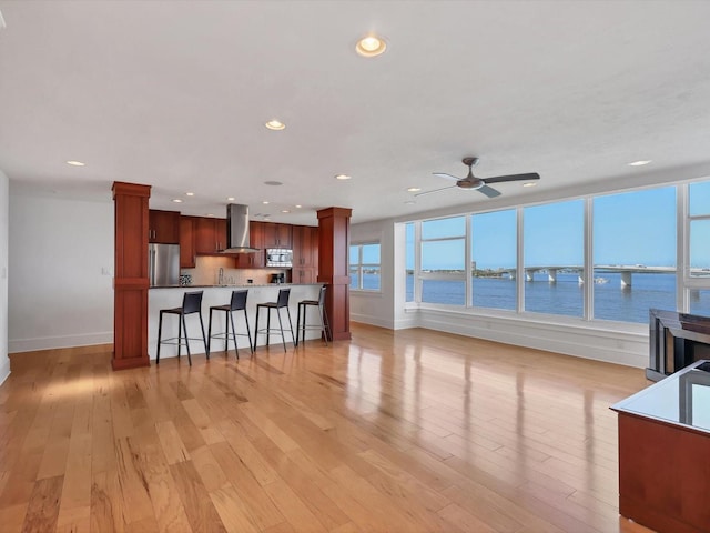 226 Golden Gate Pt Unit 63, Sarasota, FL 34236 - kitchen with stainless steel appliances, ventilation hood, a kitchen breakfast bar, baseboards, and ornate columns