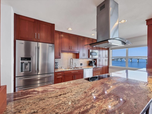 226 Golden Gate Pt Unit 63, Sarasota, FL 34236 - kitchen with appliances with stainless steel finishes, island range hood, a sink, decorative backsplash, and stone countertops