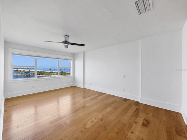 226 Golden Gate Pt Unit 63, Sarasota, FL 34236 - unfurnished room featuring baseboards, light wood-style floors, a ceiling fan, and a water view