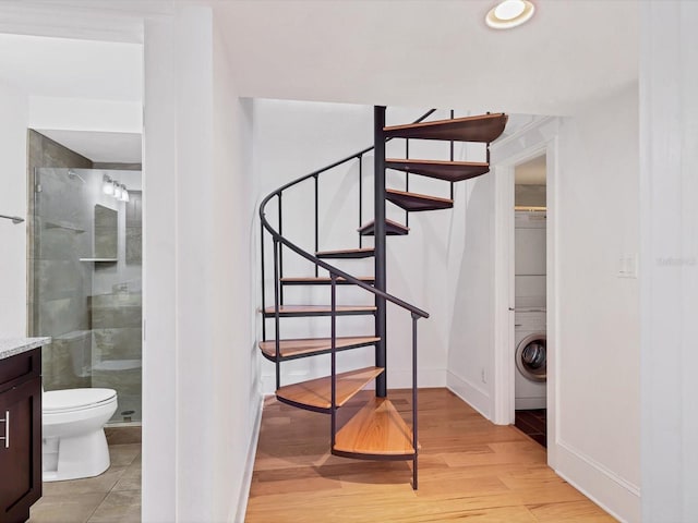 226 Golden Gate Pt Unit 63, Sarasota, FL 34236 - stairs with baseboards, washer / dryer, and wood finished floors