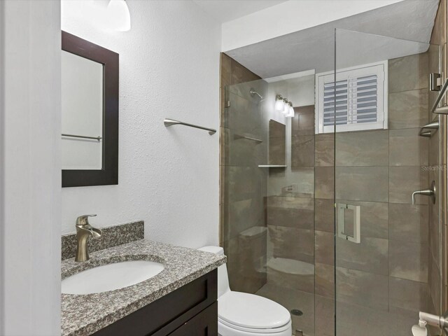 226 Golden Gate Pt Unit 63, Sarasota, FL 34236 - bathroom featuring a stall shower, toilet, and vanity