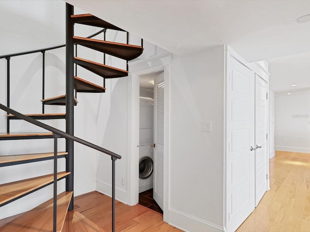 226 Golden Gate Pt Unit 63, Sarasota, FL 34236 - staircase featuring stacked washer / drying machine, wood finished floors, and baseboards