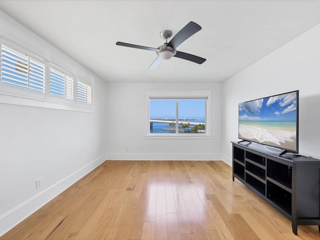 226 Golden Gate Pt Unit 63, Sarasota, FL 34236 - unfurnished living room featuring baseboards, light wood-style flooring, and a ceiling fan