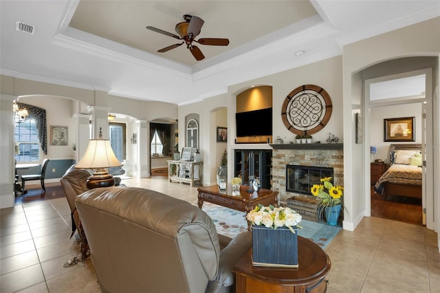 385 165th Ct NE, Bradenton, FL 34212 - living area featuring light tile patterned floors, a stone fireplace, ceiling fan, a tray ceiling, and ornate columns