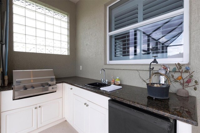 385 165th Ct NE, Bradenton, FL 34212 - kitchen featuring black dishwasher, a sink, a textured wall, dark stone counters, and white cabinets
