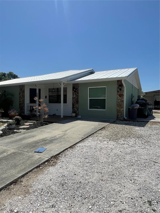 5094 Bunyan St, Sarasota, FL 34232 - rear view of property with stone siding, covered porch, metal roof, and a standing seam roof