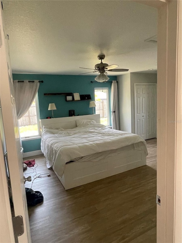 5094 Bunyan St, Sarasota, FL 34232 - bedroom with wood finished floors, multiple windows, a textured ceiling, baseboards, and ceiling fan