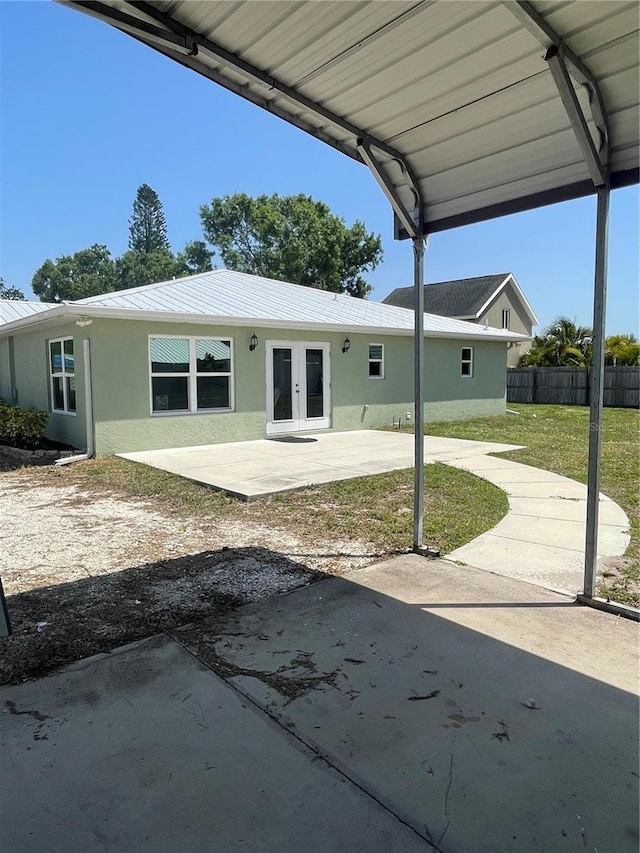 5094 Bunyan St, Sarasota, FL 34232 - back of house featuring a patio, french doors, stucco siding, fence, and metal roof