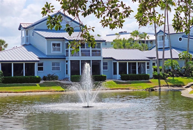 1311 Siesta Bayside Dr Unit 1311-A, Sarasota, FL 34242 - back of house with metal roof, a standing seam roof, a water view, a balcony, and a sunroom