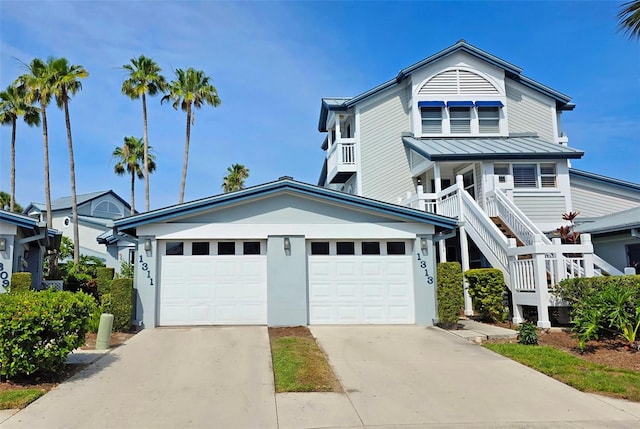 1311 Siesta Bayside Dr Unit 1311-A, Sarasota, FL 34242 - view of front of home featuring concrete driveway, a garage, a standing seam roof, metal roof, and stairway