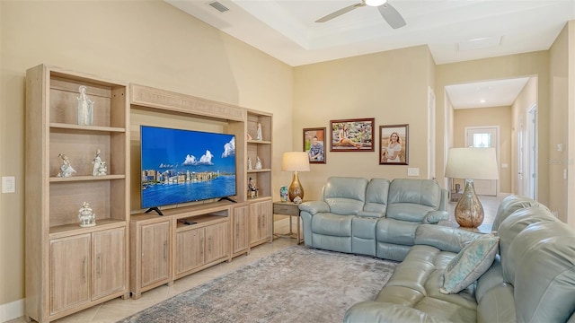 living area featuring light tile patterned floors, a ceiling fan, and built in shelves