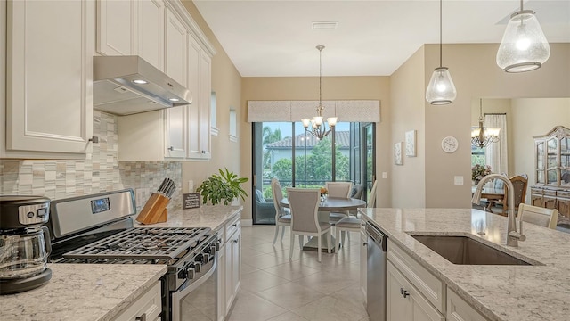kitchen featuring appliances with stainless steel finishes, a chandelier, a sink, and ventilation hood