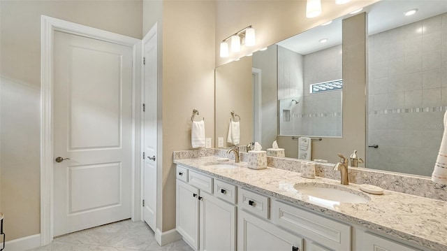 full bath with double vanity, baseboards, and walk in shower