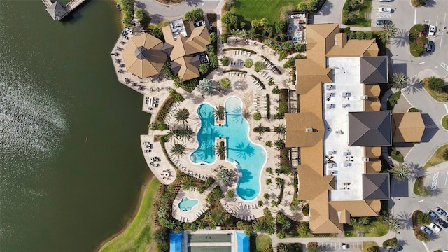 drone / aerial view of a pool and a nearby body of water