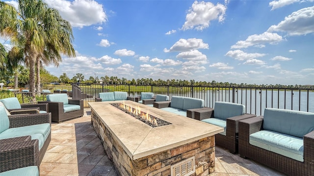 view of patio featuring an outdoor living space with a fire pit and a water view