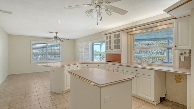 4361 Pompano Ln, Palmetto, FL 34221 - kitchen with a sink, a peninsula, a ceiling fan, light countertops, and light tile patterned flooring
