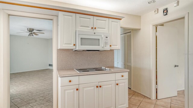 4361 Pompano Ln, Palmetto, FL 34221 - kitchen featuring white microwave, electric stovetop, light countertops, ceiling fan, and light tile patterned floors