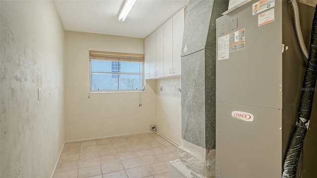 4361 Pompano Ln, Palmetto, FL 34221 - laundry room with heating unit, cabinet space, baseboards, and light tile patterned flooring