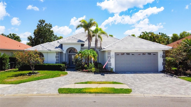 4239 Corso Venetia Blvd, Venice, FL 34293 - view of front facade featuring an attached garage, a tiled roof, stucco siding, and decorative driveway