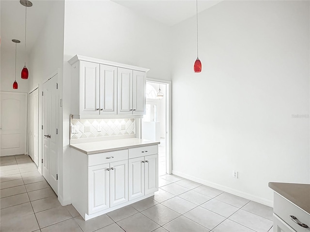 4239 Corso Venetia Blvd, Venice, FL 34293 - kitchen featuring high vaulted ceiling, light tile patterned floors, tasteful backsplash, hanging light fixtures, and white cabinets