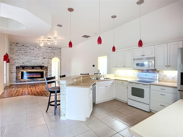 4239 Corso Venetia Blvd, Venice, FL 34293 - kitchen with stainless steel appliances, a sink, light tile patterned floors, open floor plan, and a peninsula