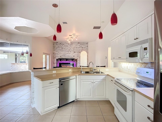 4239 Corso Venetia Blvd, Venice, FL 34293 - kitchen featuring white appliances, a sink, light tile patterned flooring, track lighting, and a peninsula