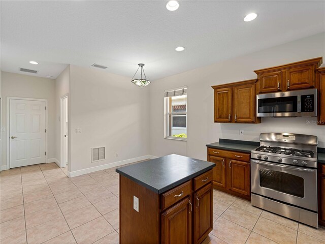 6248 Donnington Ct, Sarasota, FL 34238 - kitchen featuring appliances with stainless steel finishes, dark countertops, light tile patterned flooring, brown cabinets, and recessed lighting