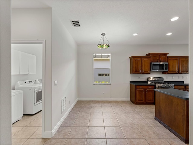 6248 Donnington Ct, Sarasota, FL 34238 - kitchen with appliances with stainless steel finishes, separate washer and dryer, dark countertops, light tile patterned floors, and baseboards