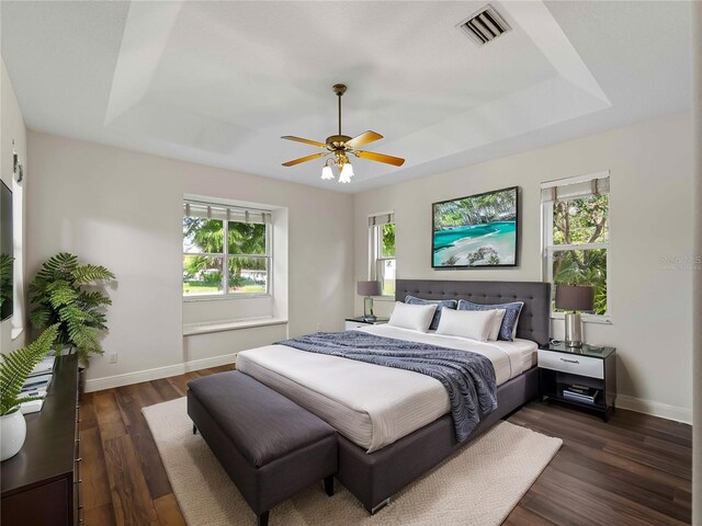 6248 Donnington Ct, Sarasota, FL 34238 - bedroom with a raised ceiling, baseboards, dark wood-type flooring, and a ceiling fan