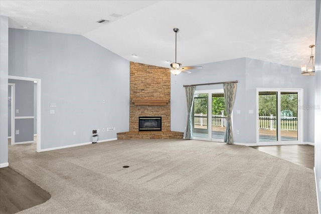 10001 289th St E, Myakka City, FL 34251 - unfurnished living room with a stone fireplace, ceiling fan, carpet floors, a chandelier, and high vaulted ceiling