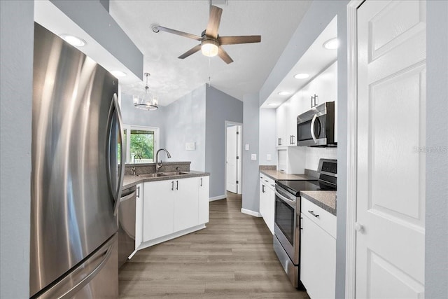 10001 289th St E, Myakka City, FL 34251 - kitchen with appliances with stainless steel finishes, white cabinetry, light wood-type flooring, ceiling fan, and recessed lighting