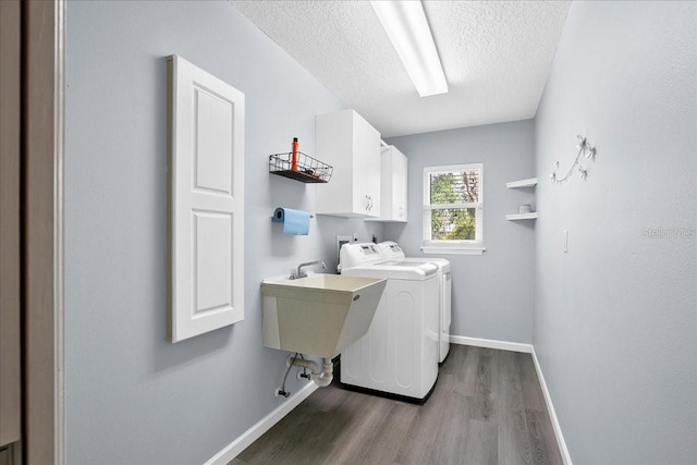 10001 289th St E, Myakka City, FL 34251 - laundry area with cabinet space, washing machine and clothes dryer, dark wood-style floors, and a textured ceiling