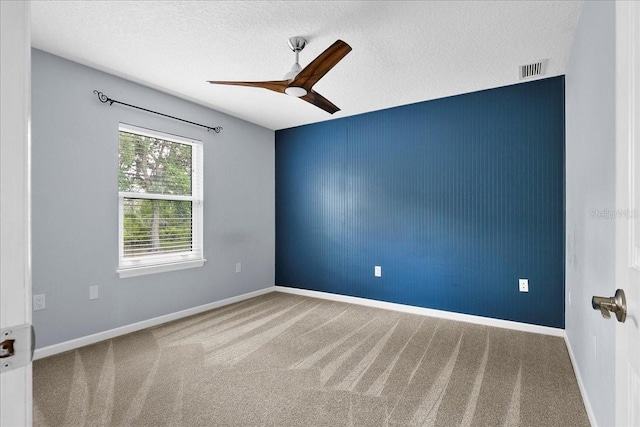10001 289th St E, Myakka City, FL 34251 - empty room featuring ceiling fan, carpet floors, an accent wall, and a textured ceiling