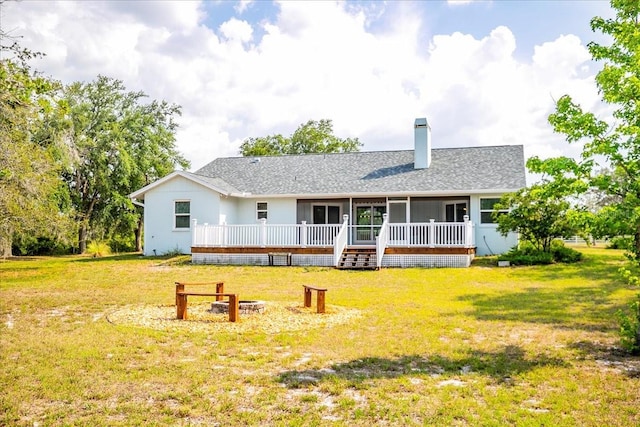 10001 289th St E, Myakka City, FL 34251 - rear view of house featuring a yard, a chimney, a wooden deck, and a sunroom