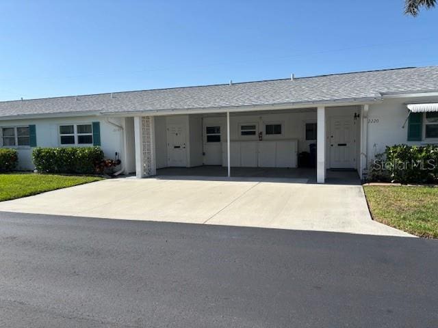 2218 Orange Blossom Ln Unit 0, Bradenton, FL 34207 - single story home featuring concrete driveway, a carport, stucco siding, a front lawn, and roof with shingles