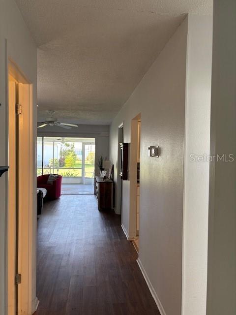 2218 Orange Blossom Ln Unit 0, Bradenton, FL 34207 - hall with dark wood finished floors, a textured ceiling, and baseboards